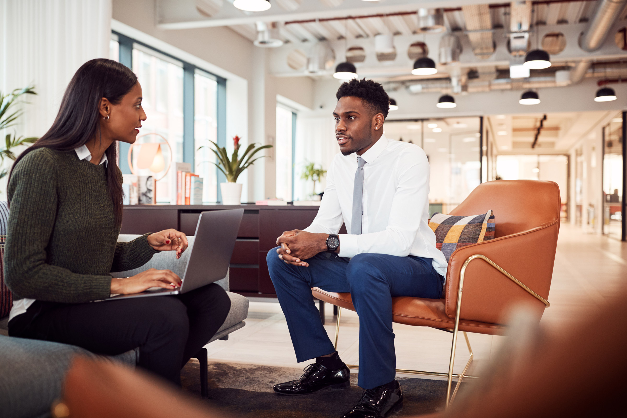 Two coworkers sitting having a meeting in the office