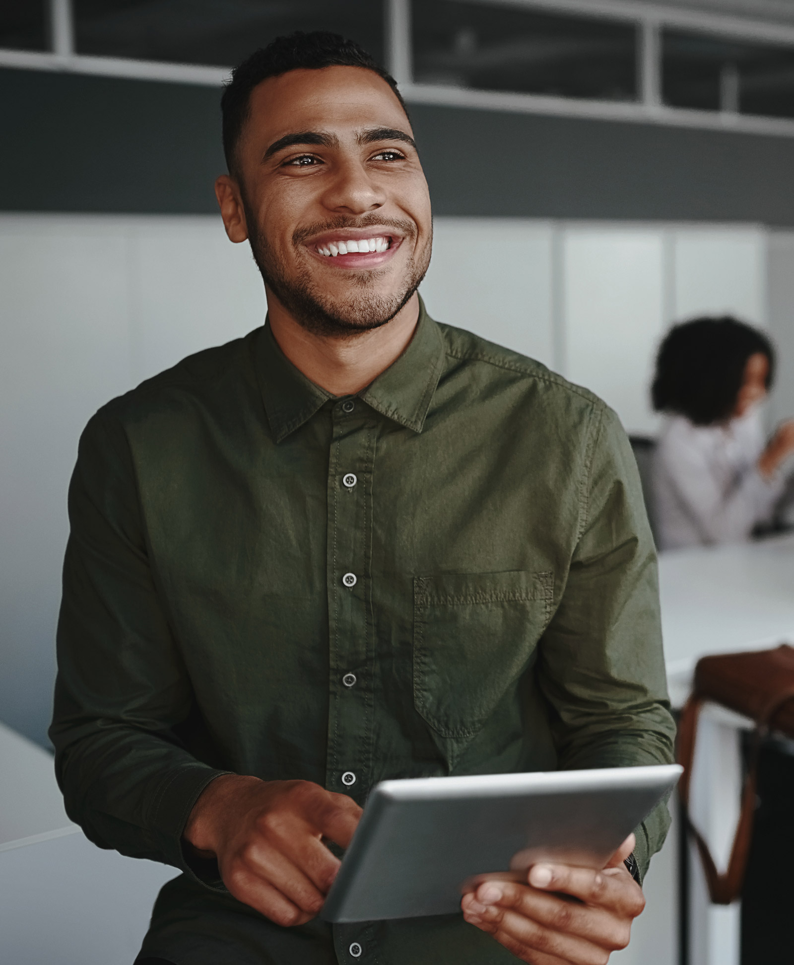 An employee standing smiling with a tablet