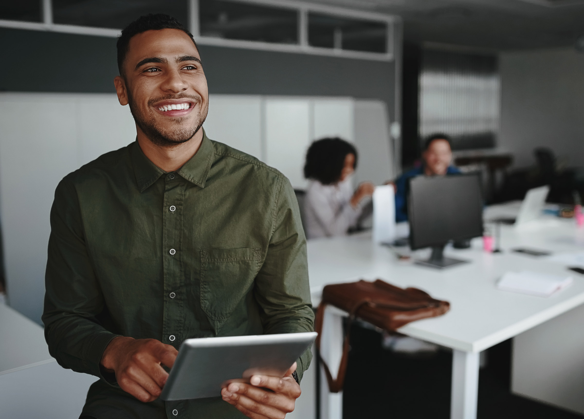 An employee standing smiling with a tablet