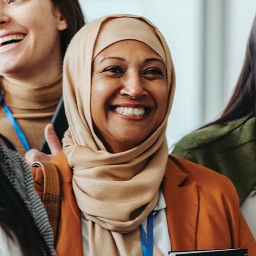 An employee smiling in a conference crowd